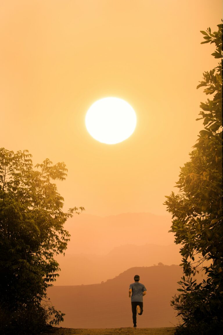 Man running towards the sun during a hot summer sunset