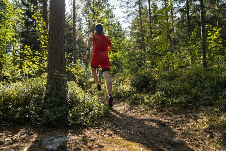A trail runner moving through a forest